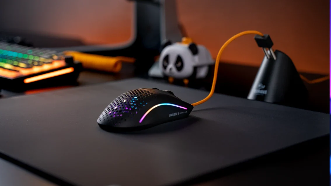 A Glorious mouse with a Glorious Gold Ascended Cable on a desk